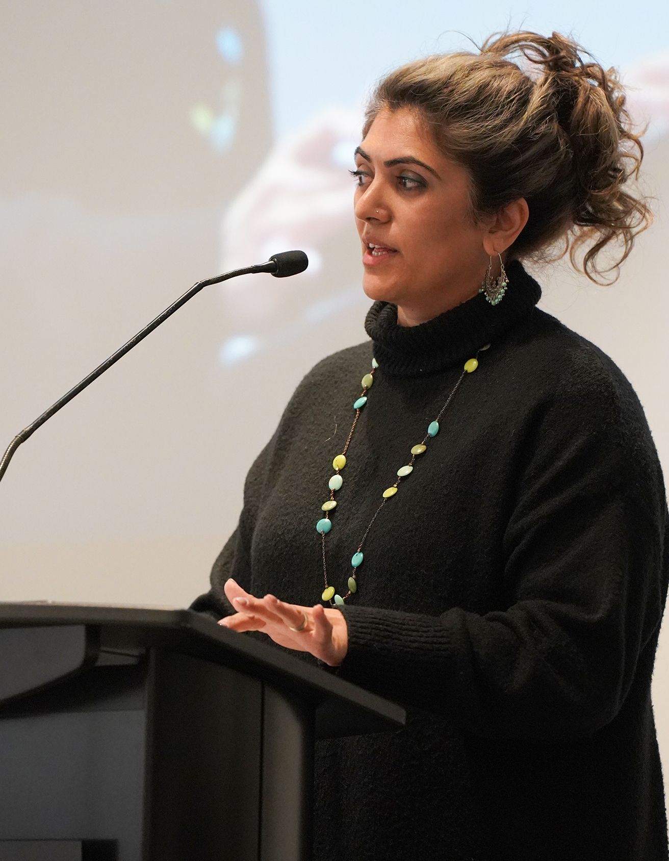 Somia Sadiq founder of Narratives Inc speaking into a microphone