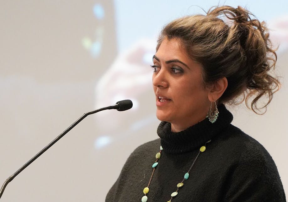 Somia Sadiq founder of Narratives Inc speaking into a microphone