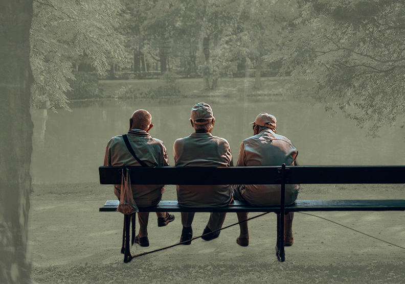 The older men sit on a park bench overlooking a body of water outside.