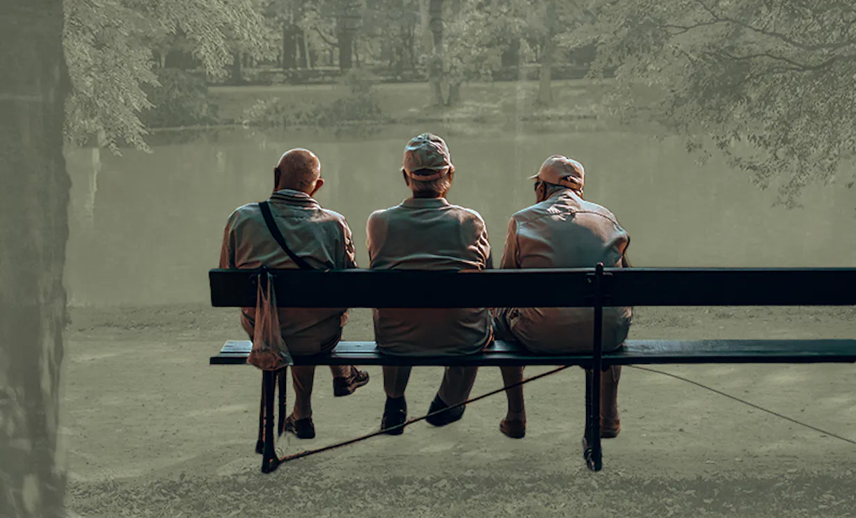 The older men sit on a park bench overlooking a body of water outside.