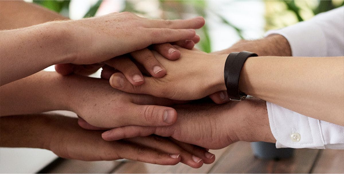 Close up of several hands stacked on top of each other