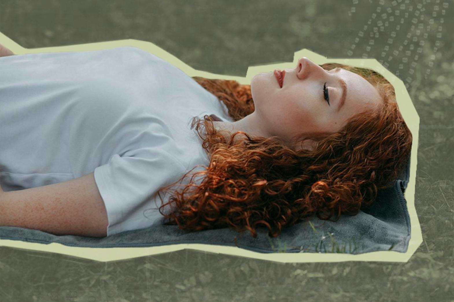 Woman laying in the grass peacefully with her eyes closed