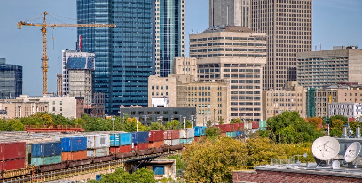 A train makes its way through a city with many tall buildings