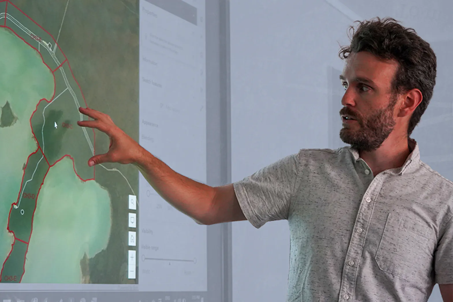 A man points to a map on a computer screen during a digital mapping exercise