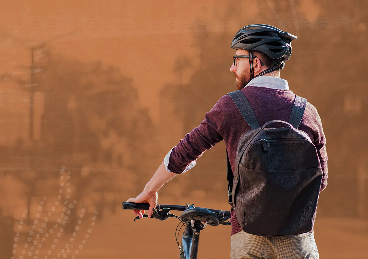 Male commuter wearing bike helmet in a town.