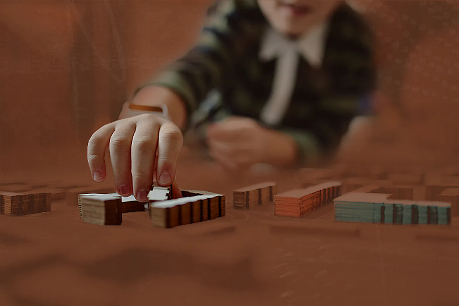 A child playing with wooden building blocks on a coffee table.