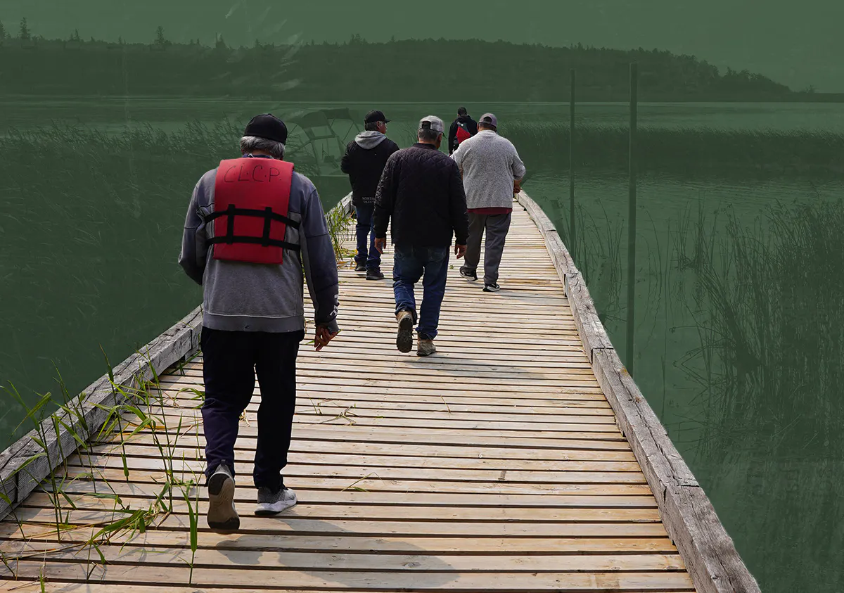 People walking on a dock wearing life jackets. A lake and hills are in the horizon.