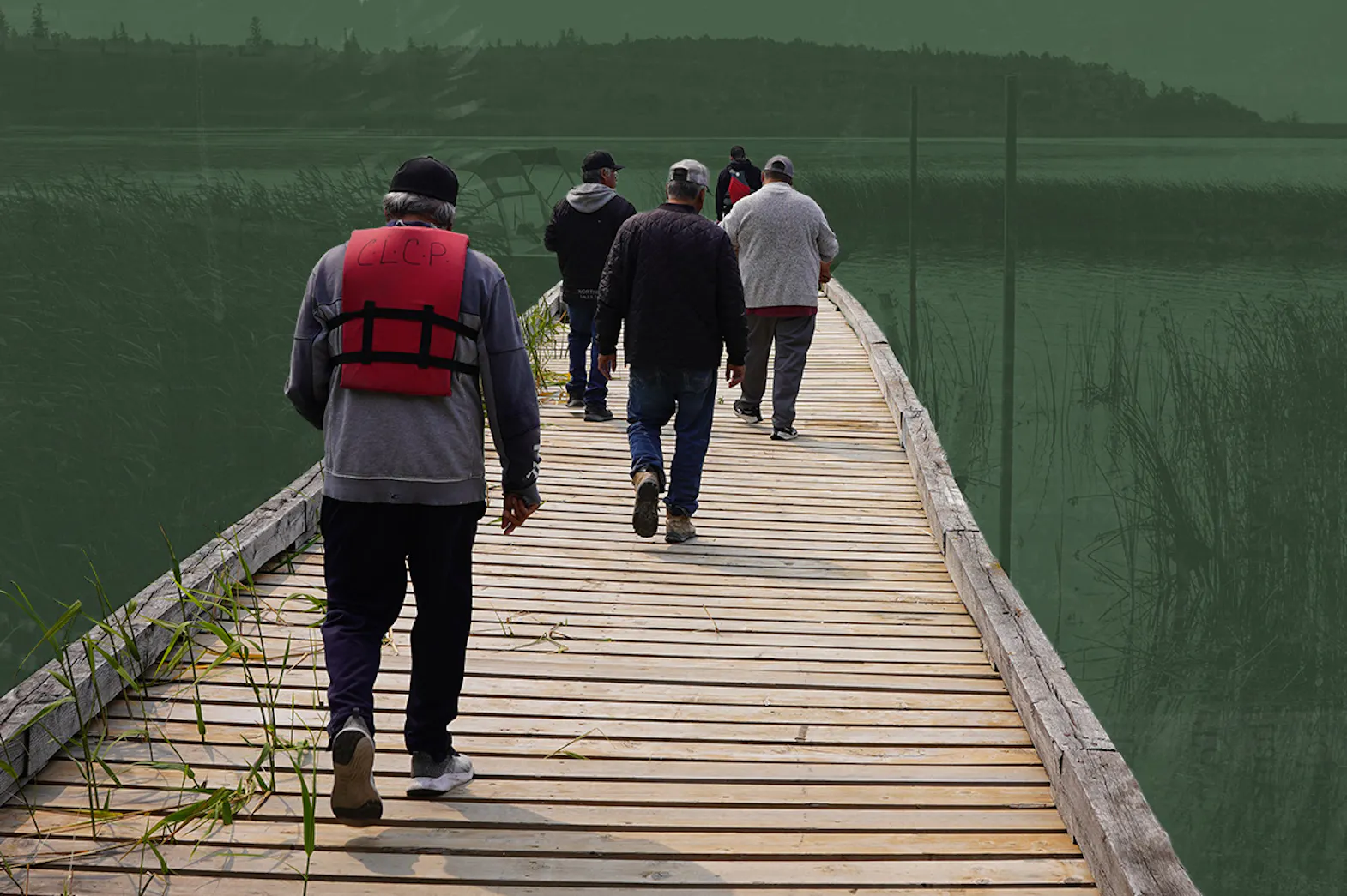 People walking on a dock wearing life jackets. A lake and hills are in the horizon.