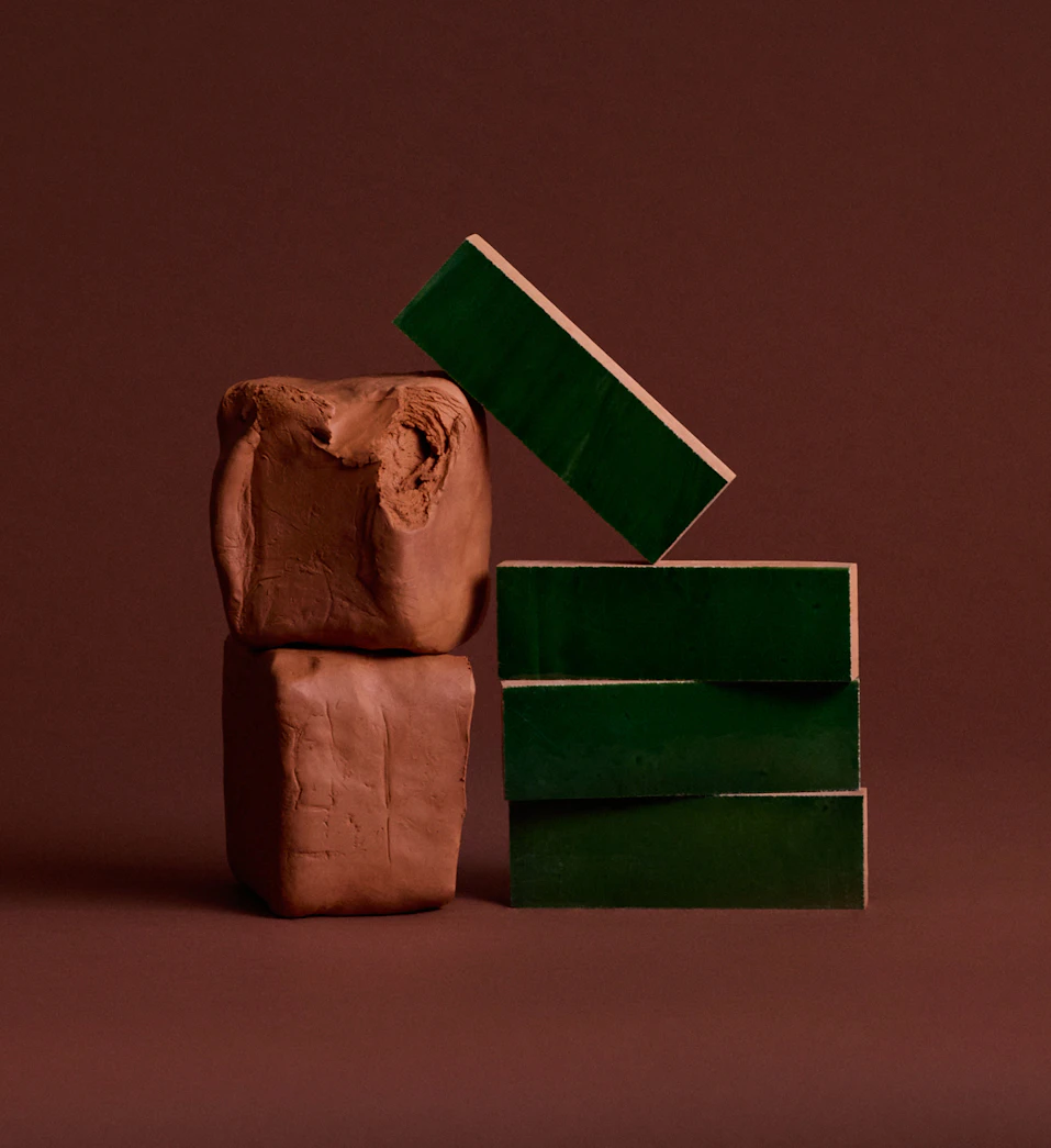 Dark green clay tiles stacked next to blocks of clay.