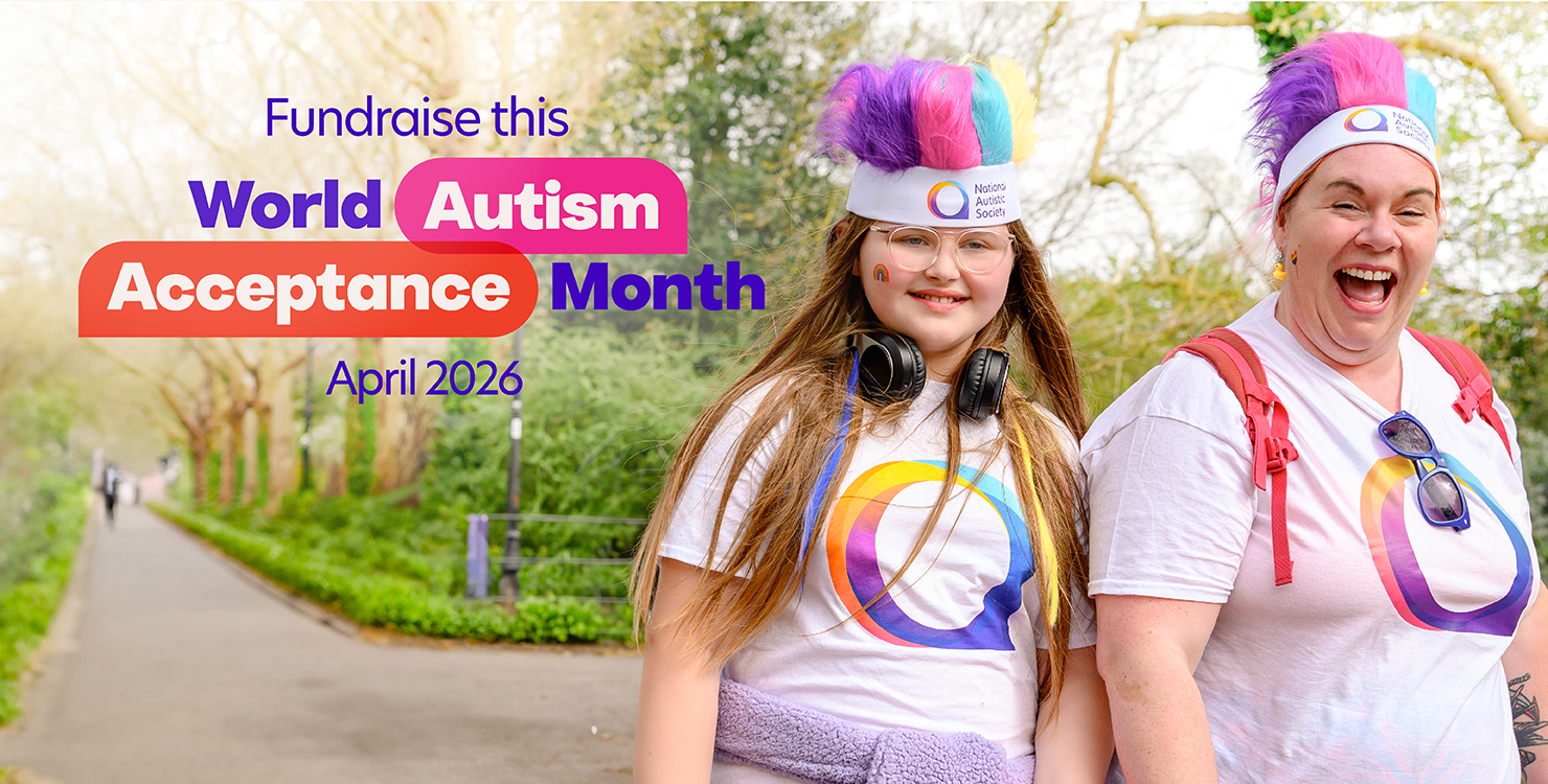 Two people smile for the camera on a path in a park. Both wear matching t-shirts and colourful, fluffy headbands. Text overlay reads, 'Fundraise this World Autism Acceptance Month April 2026