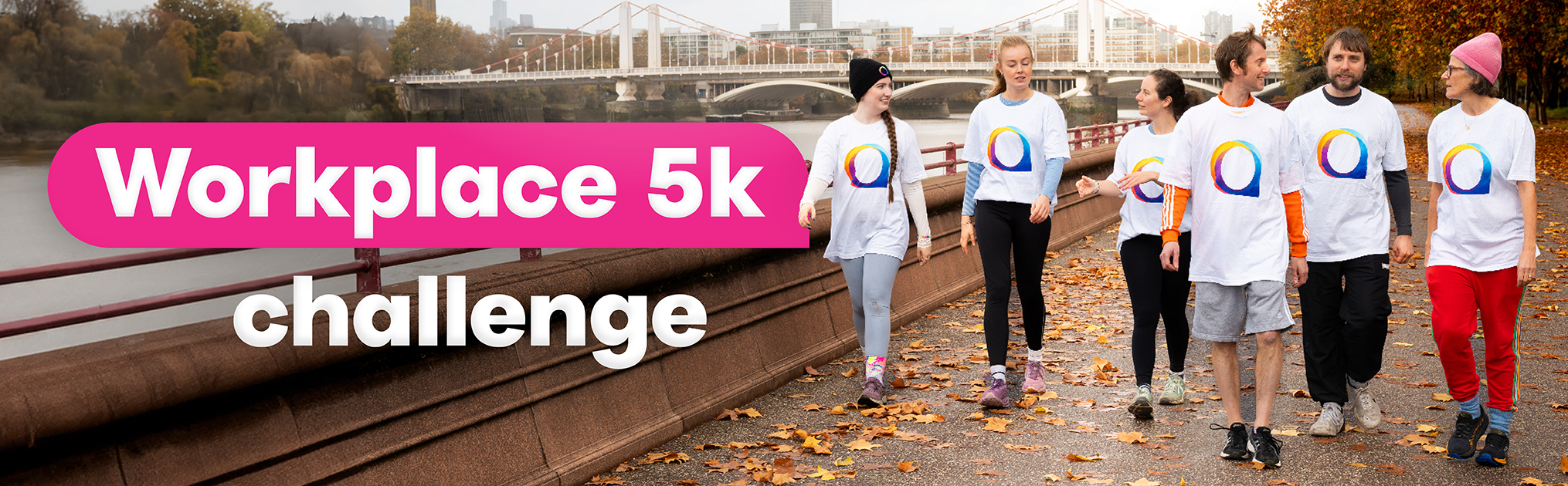 A group of adults wearing National Autistic Society T-shirts walk together along a riverside path lined with autumn leaves. A bridge and city buildings appear in the background. Large text on the image reads 'Workplace 5k challenge'.