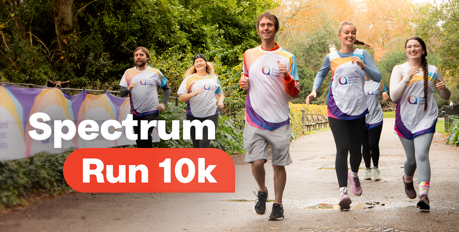 A group of smiling runners wearing National Autistic Society–branded shirts jog along a tree-lined park path. A large banner on the left displays the charity’s logo and colourful design. Bold text on the image reads 'Spectrum Run 10k.'