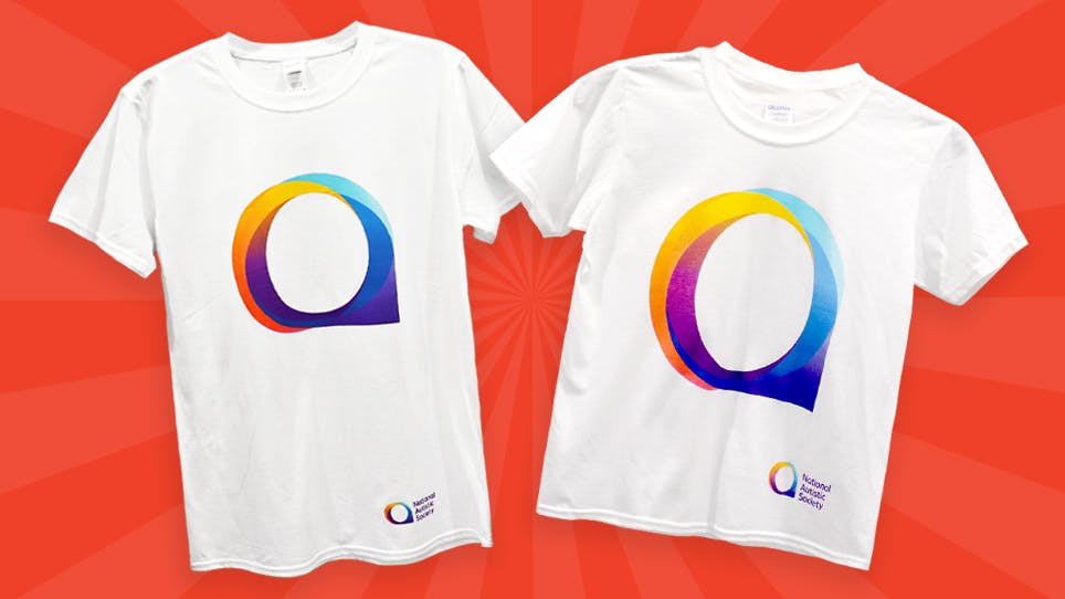 Two white T-shirts with a colorful circular logo and ‘National Autistic Society’ text on a red background.”
