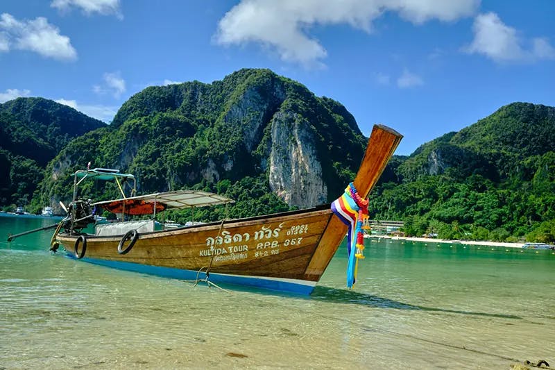Longtail boat beached Thailand - John Mukiibi Elijah on Unsplash