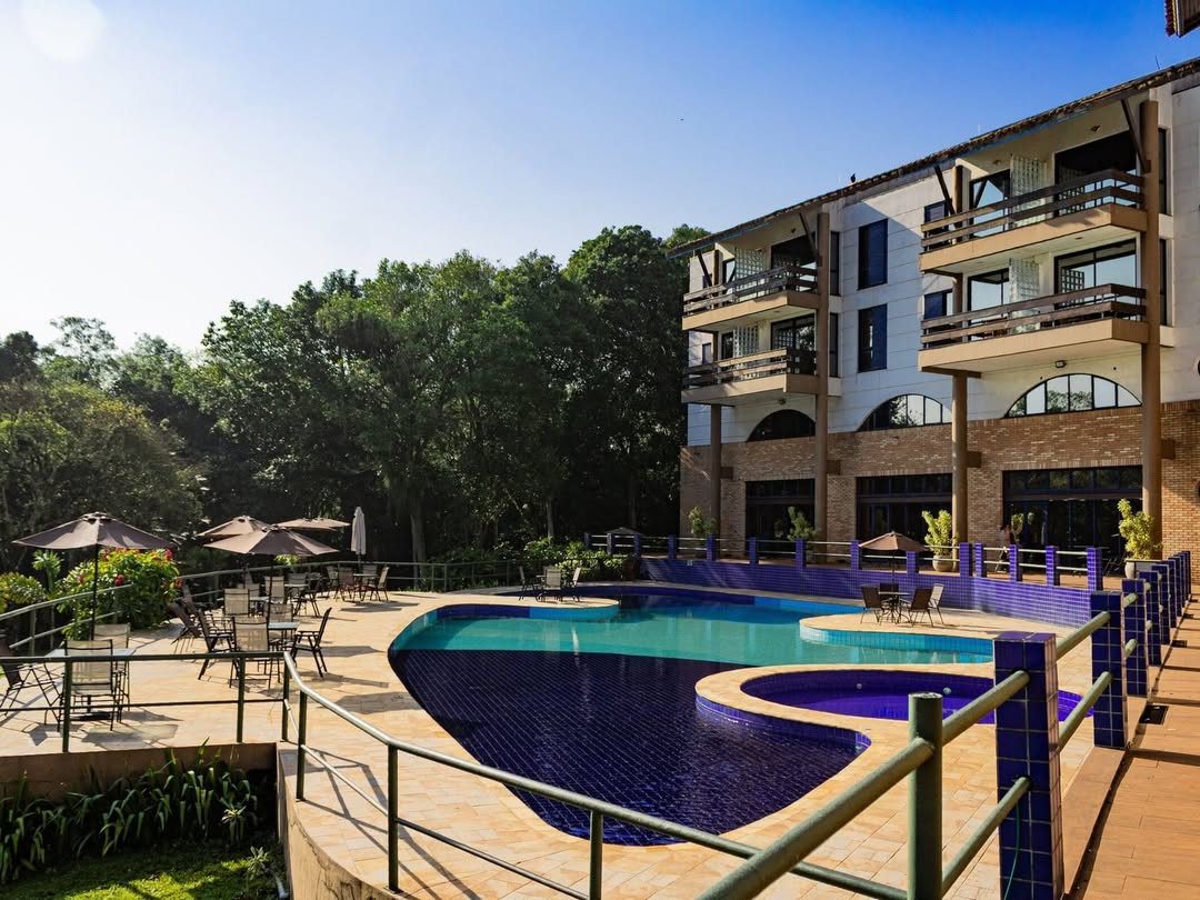 Foto panorâmica de piscina e quartos de resort na natureza