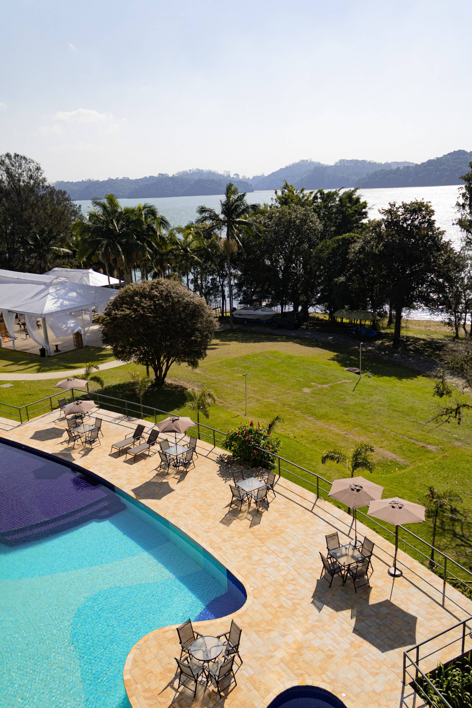 Imagem aérea de piscina e represa ao fundo