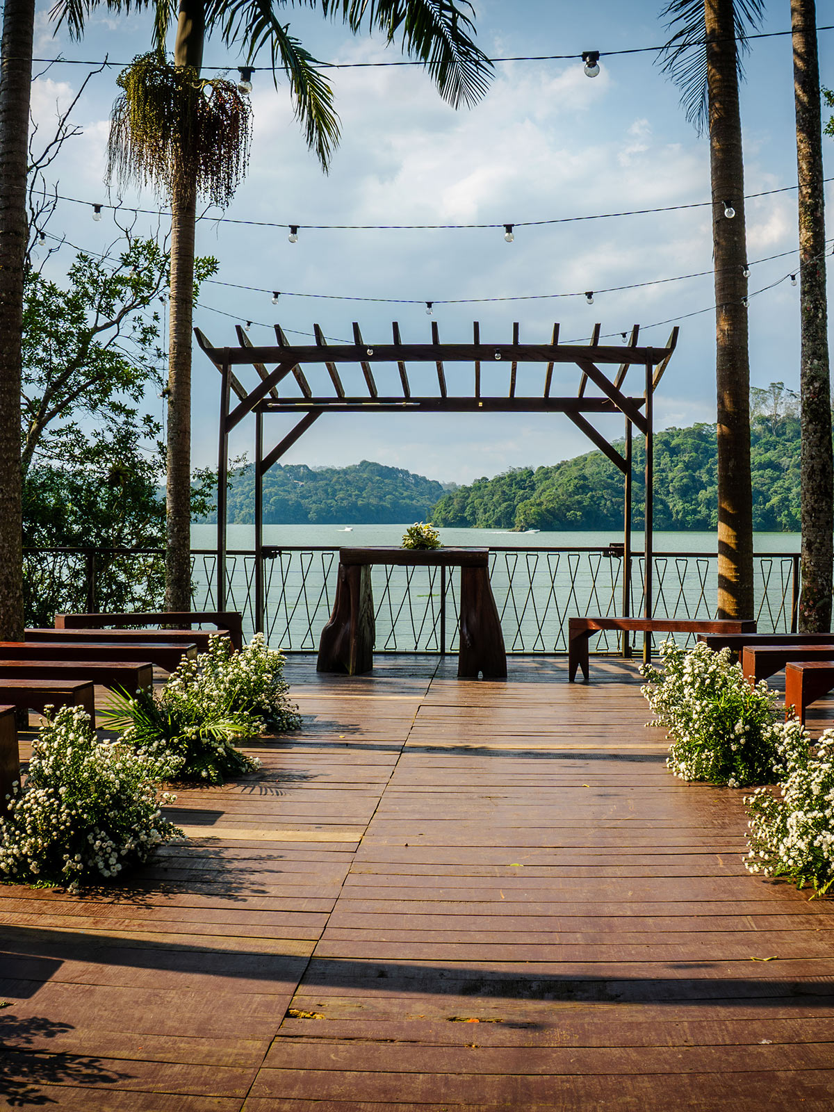 deck com coqueiros de frente a uma linda represa