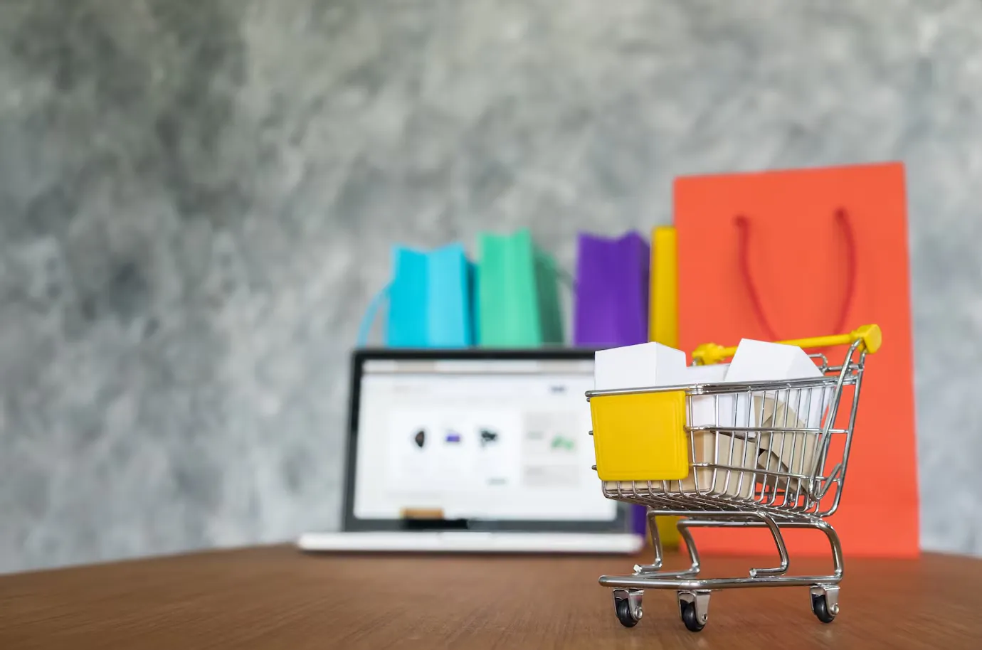 Shopping cart, shopping bags and laptop