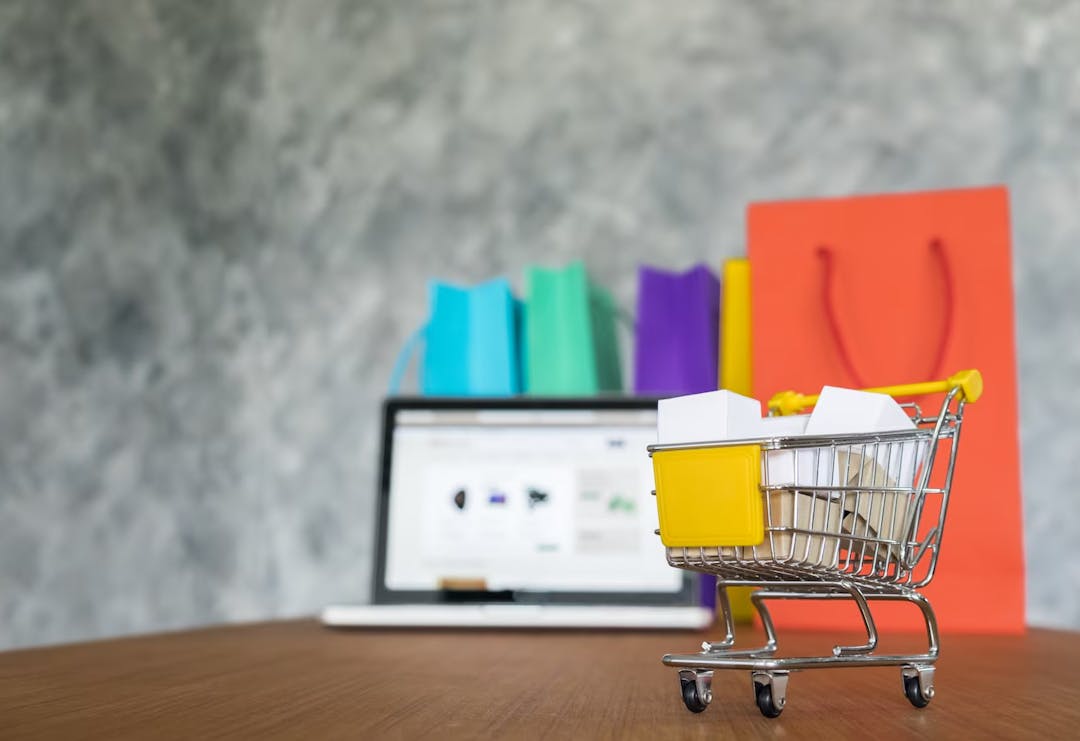 Shopping cart, shopping bags and laptop