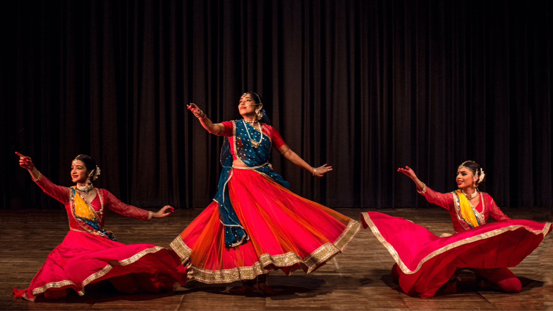 Garima Arya dancing on stage with 2 of her students