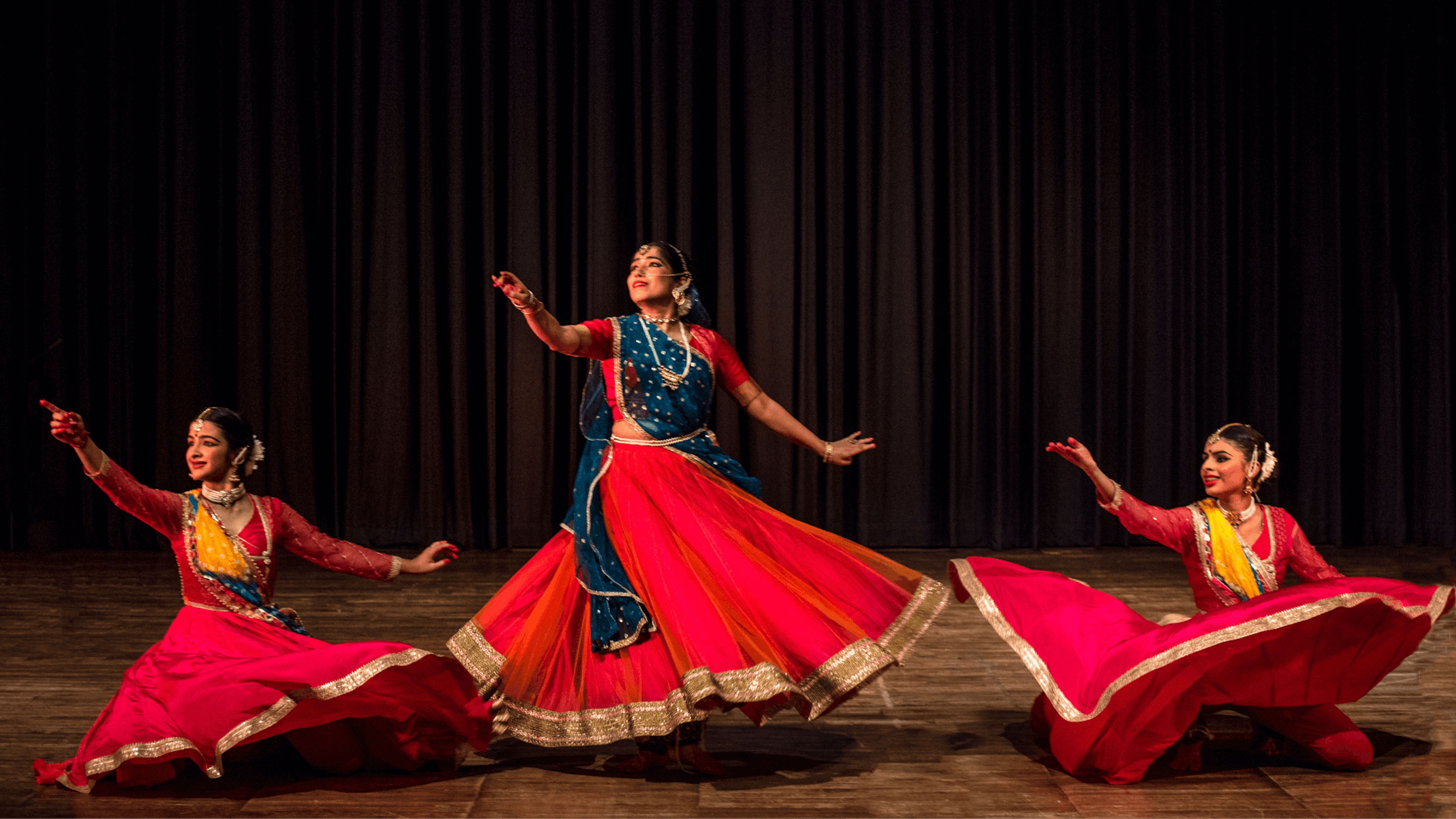 Garima Arya dancing on stage with 2 of her students