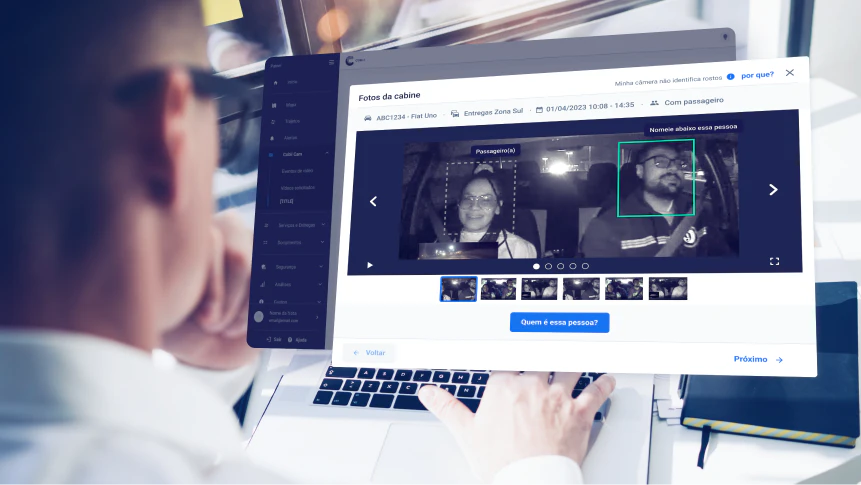 Pessoa analisando imagens de cabine de veículo com identificação automática de passageiros via inteligência artificial, em plataforma de videotelemetria.