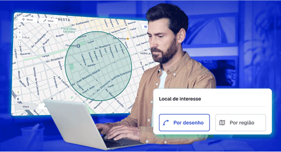 Homem utilizando notebook com mapa interativo na tela, destacando um perímetro circular de localização definido por desenho. Interface exibe função “Local de interesse” com opções de seleção por desenho ou por região. A imagem representa o uso de tecnologia de rastreamento para monitoramento de áreas estratégicas e geofencing na gestão de frotas.