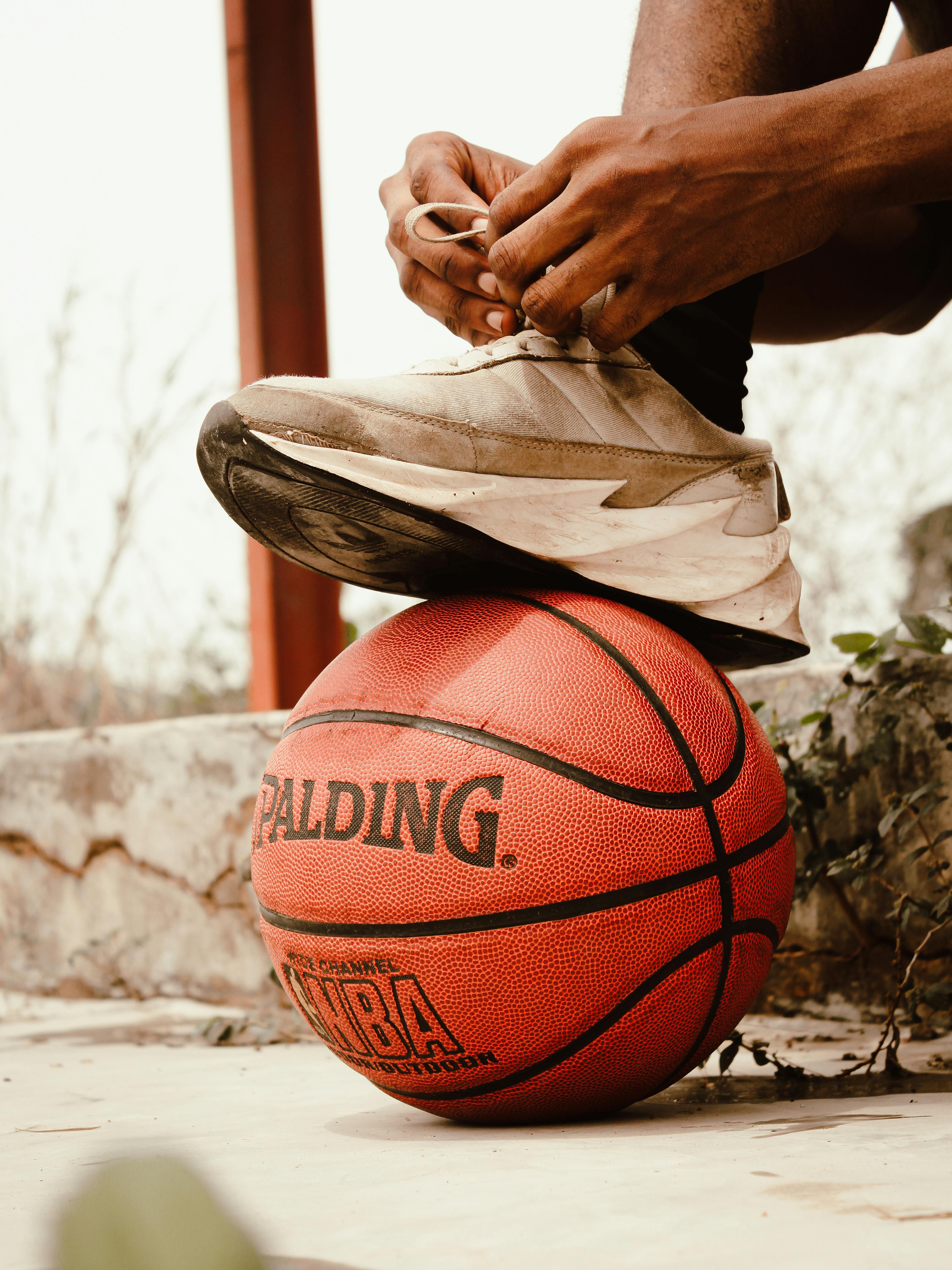 College student with foot on a basketball for March Madness