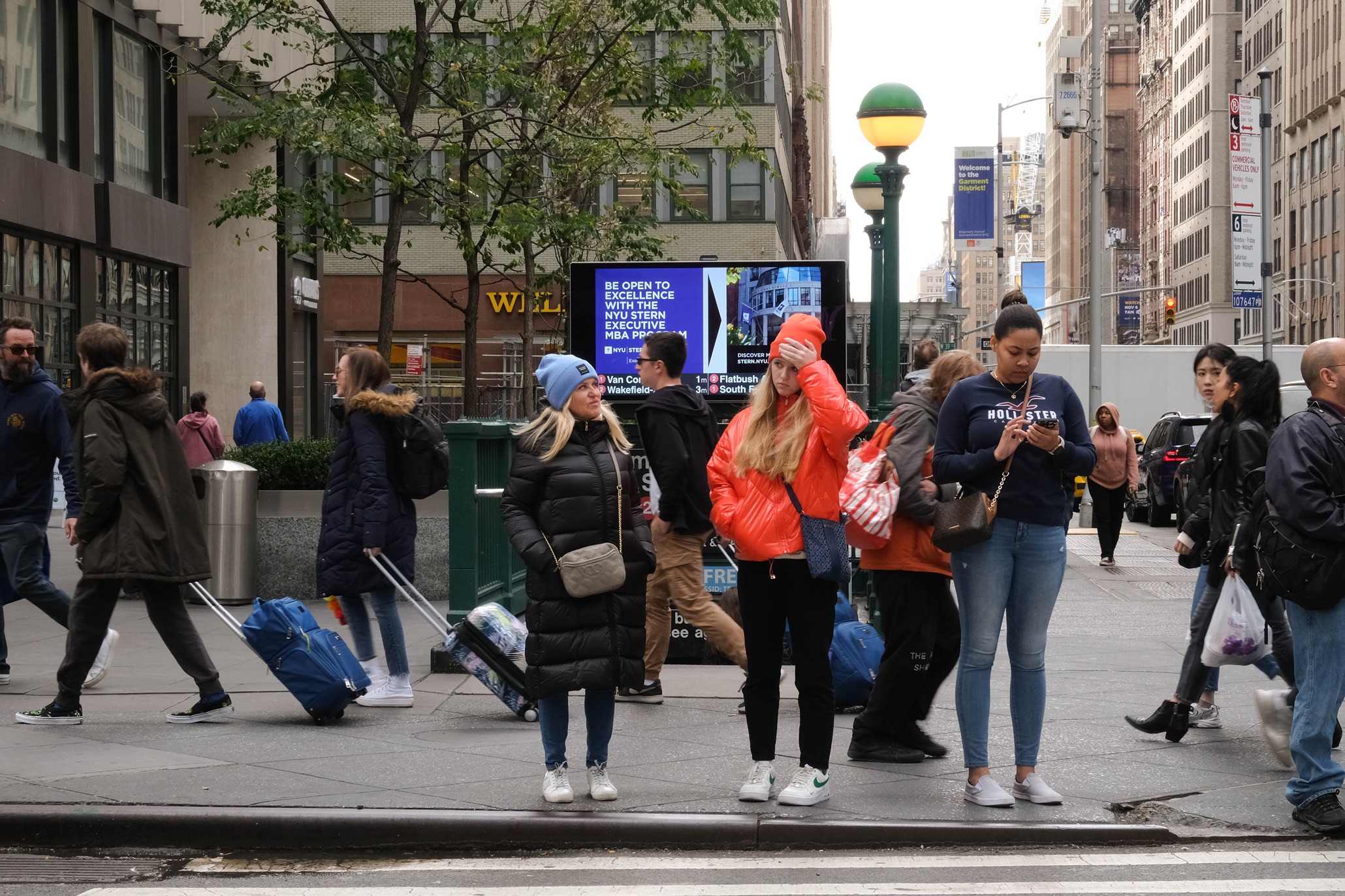Women standing in front of an NYU EMBA poster in New York