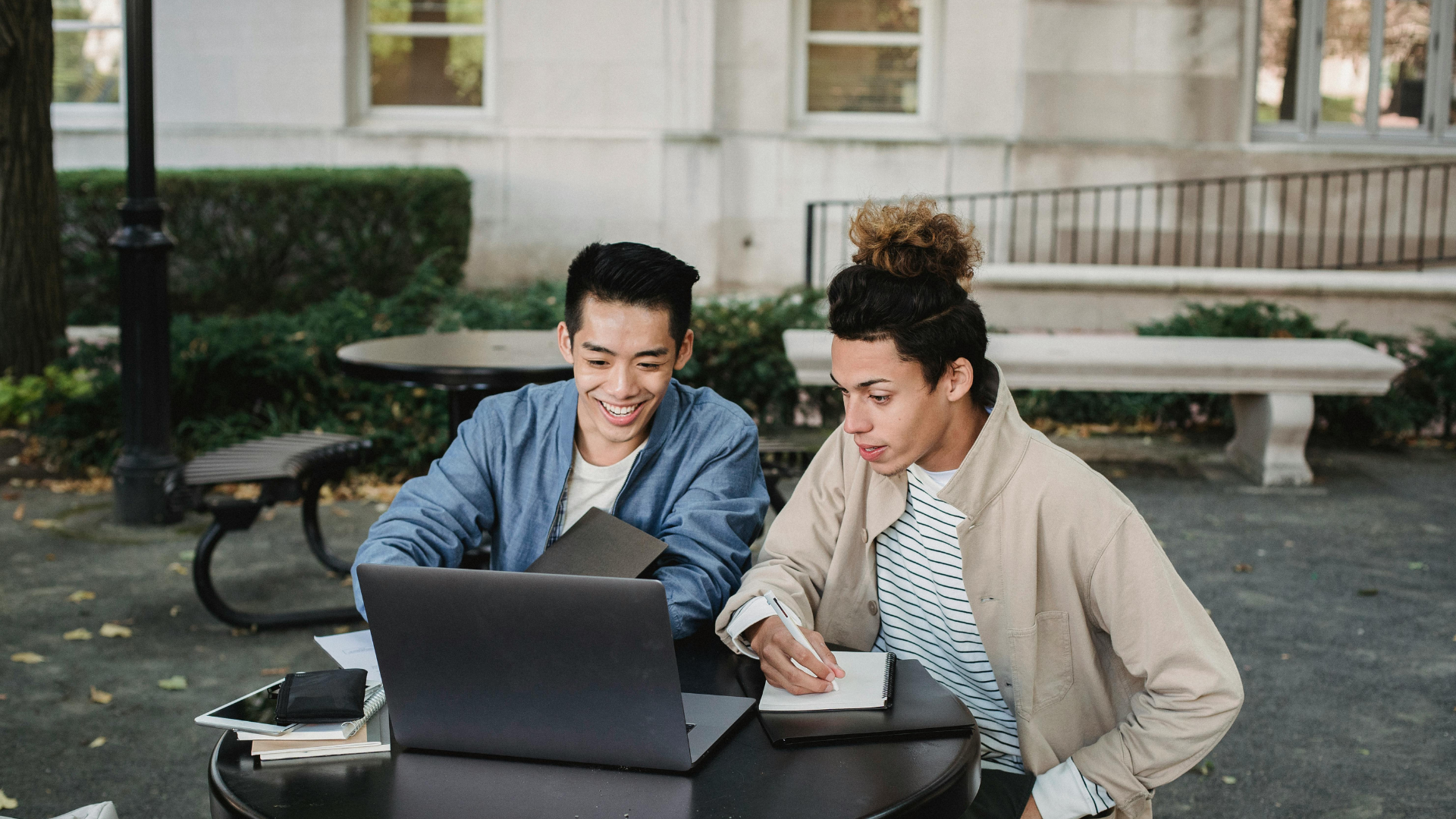 two students working from a laptop