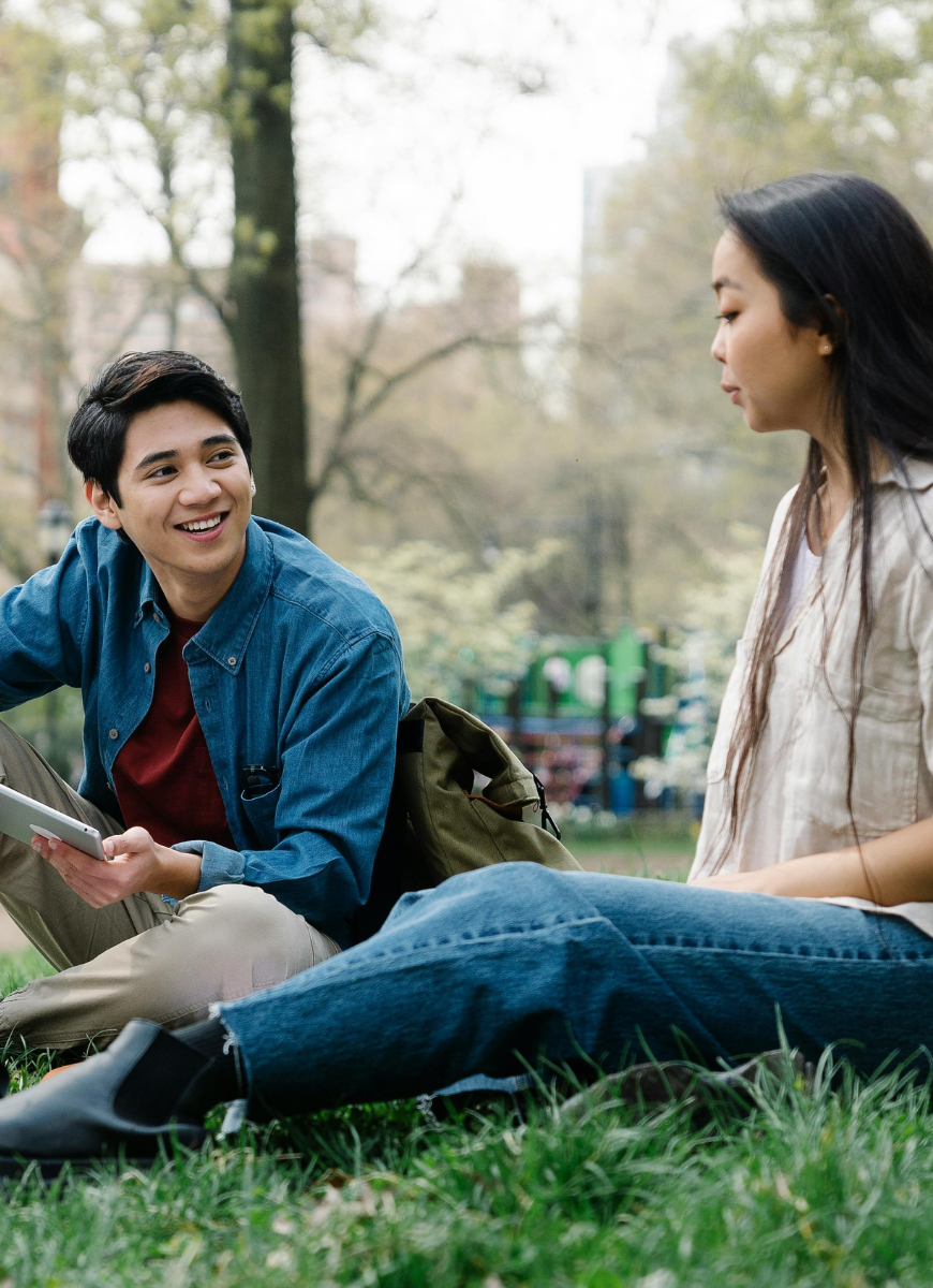 Two students sat on grass