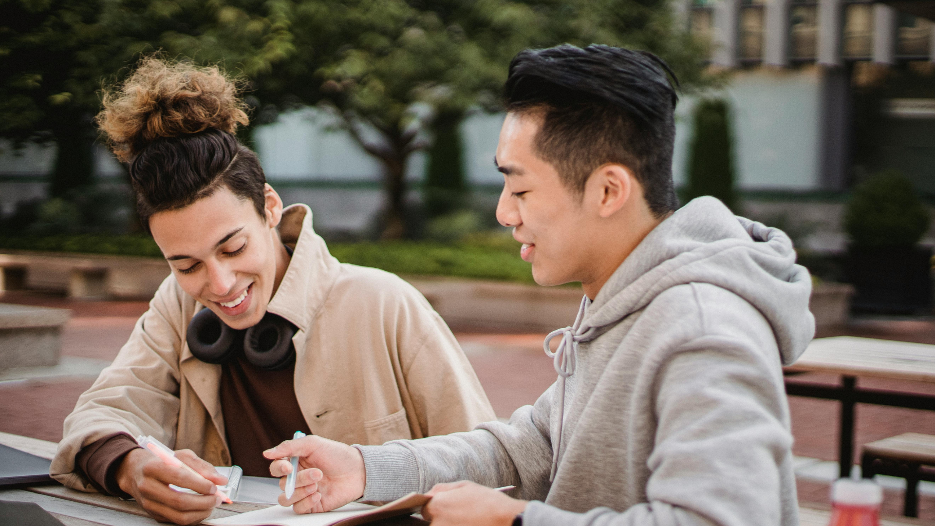 two male students sitting at a table writing