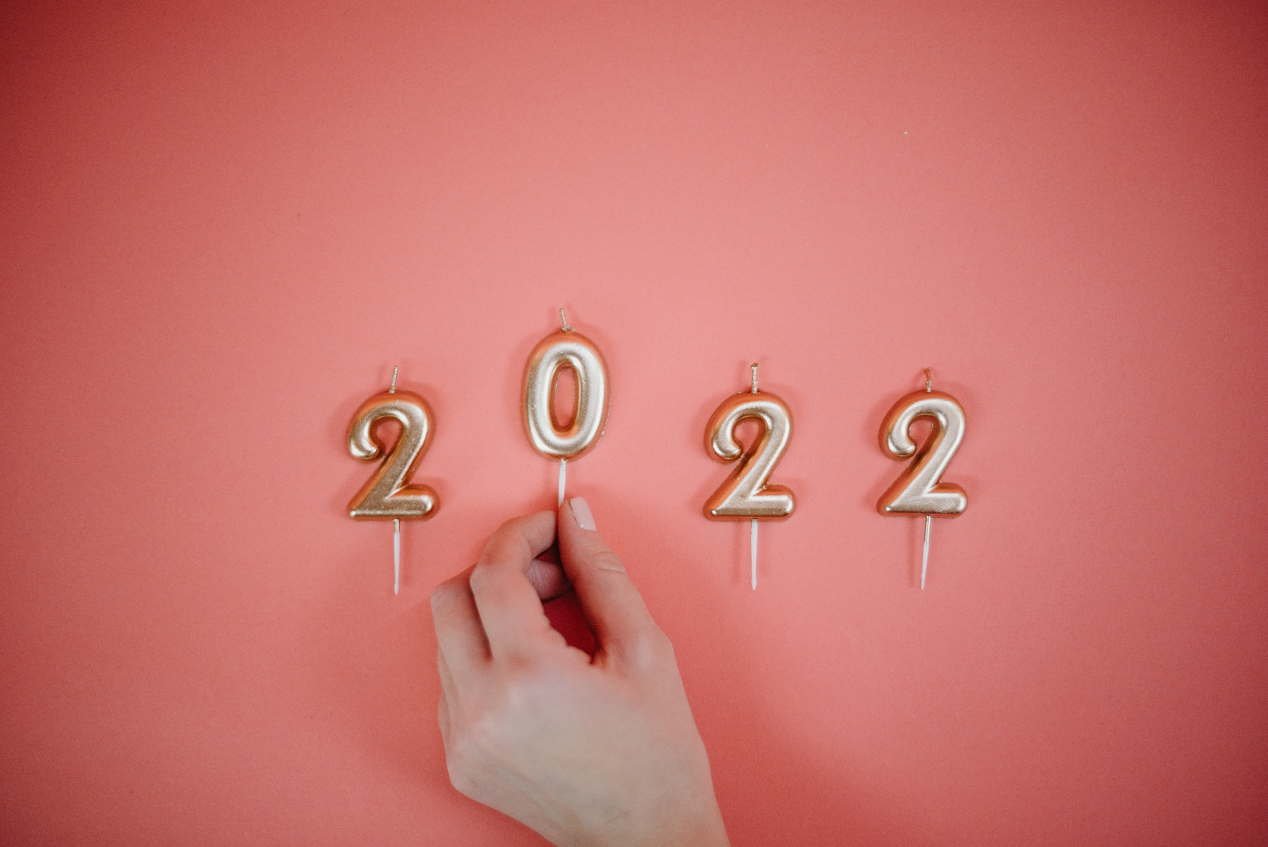 a picture of candles that spell out "2022" with a hand grabbing the zero.