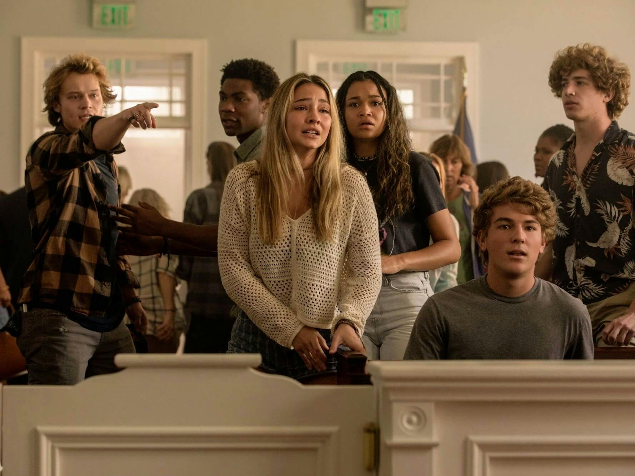 JJ (Rudy Pankow), Pope (J.D.), Sarah Cameron (Madelyn Cline), and Kiara (Madison Bailey) look distraught and angry in a courtroom. The room is filled with other people who look unconcerned.