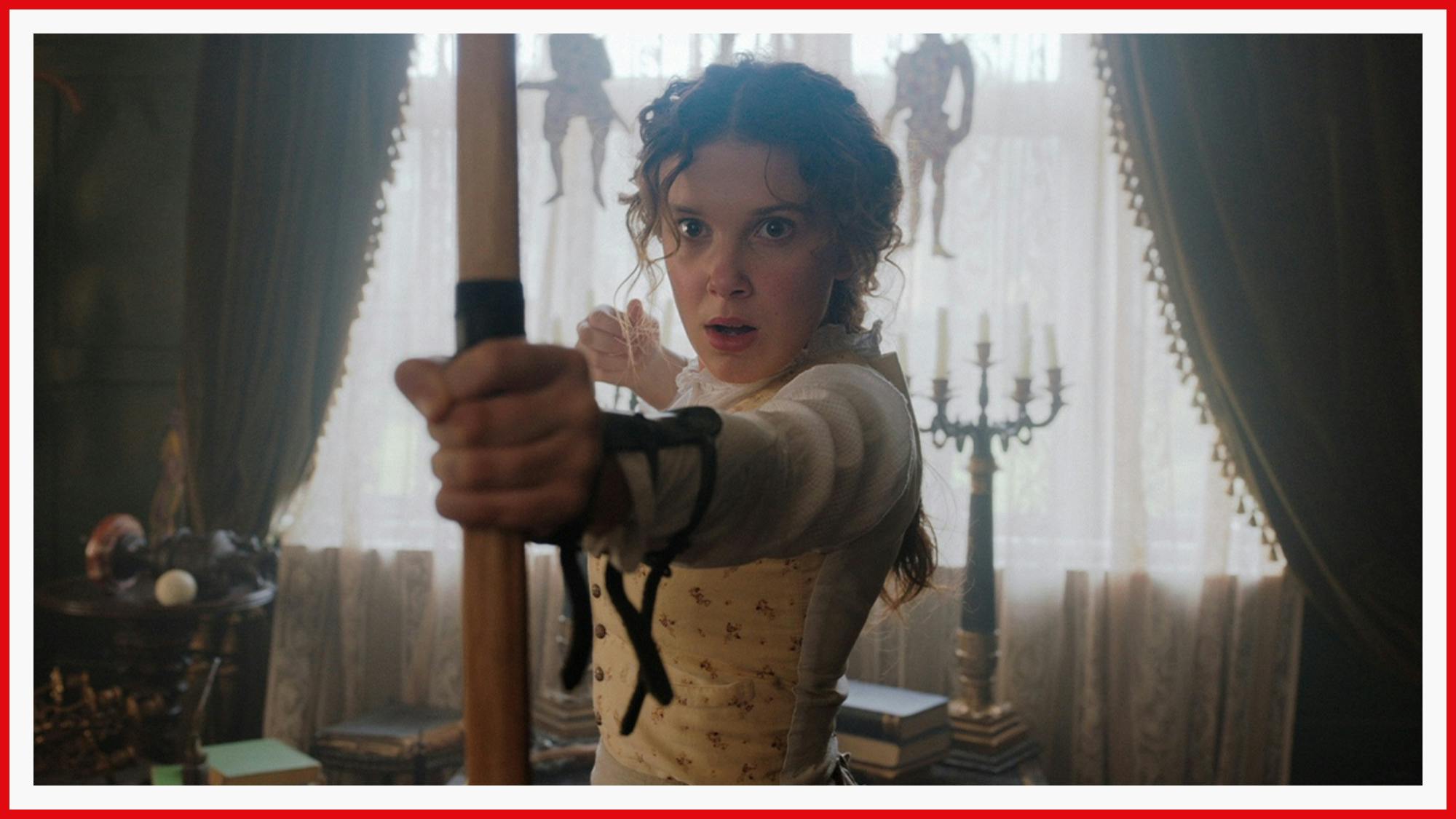 Millie Bobby Brown is prepared for a fight as Enola Holmes. Here, she holds a bow and arrow at the ready.