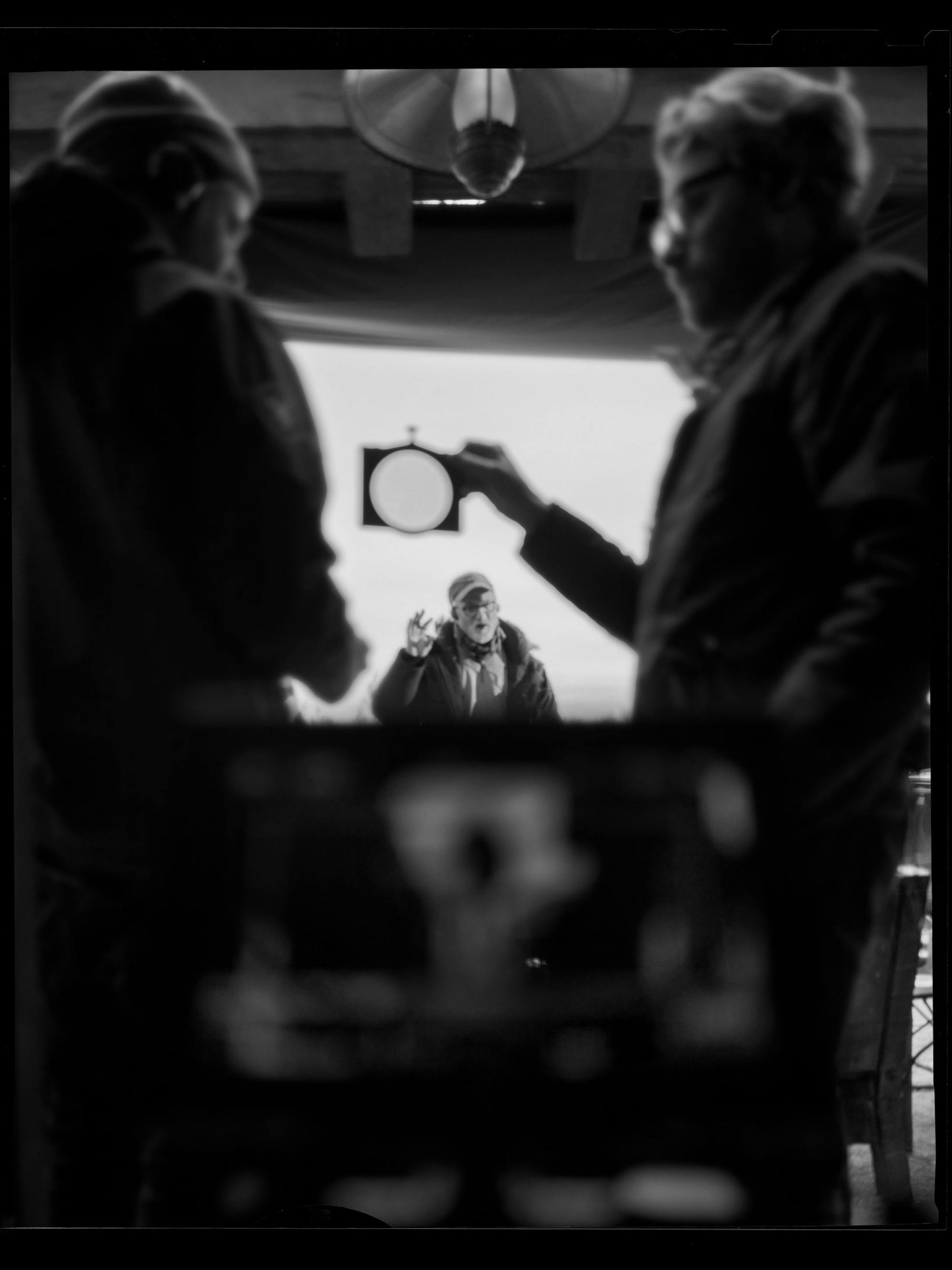 Fincher and Messerschmidt hold up a lens in this behind-the-scenes shot.