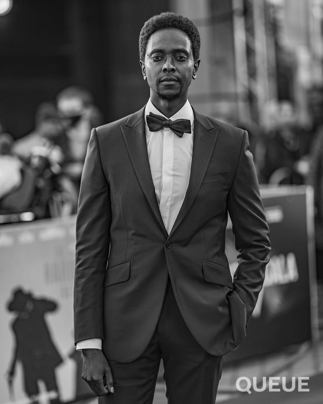 Edi Gathegi in a tux and bowtie on the red carpet