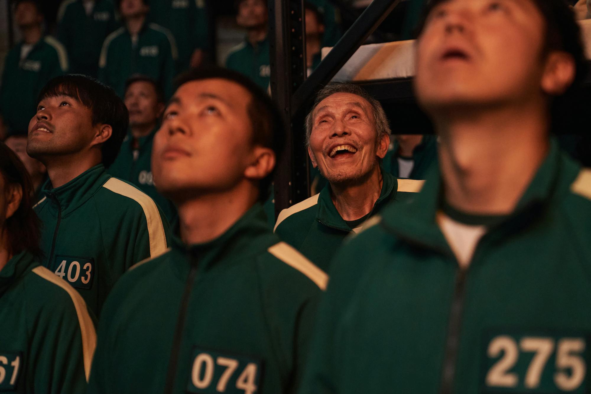 Oh Il-nam (Oh Young-soo) looks up in awe alongside other players in green tracksuits.