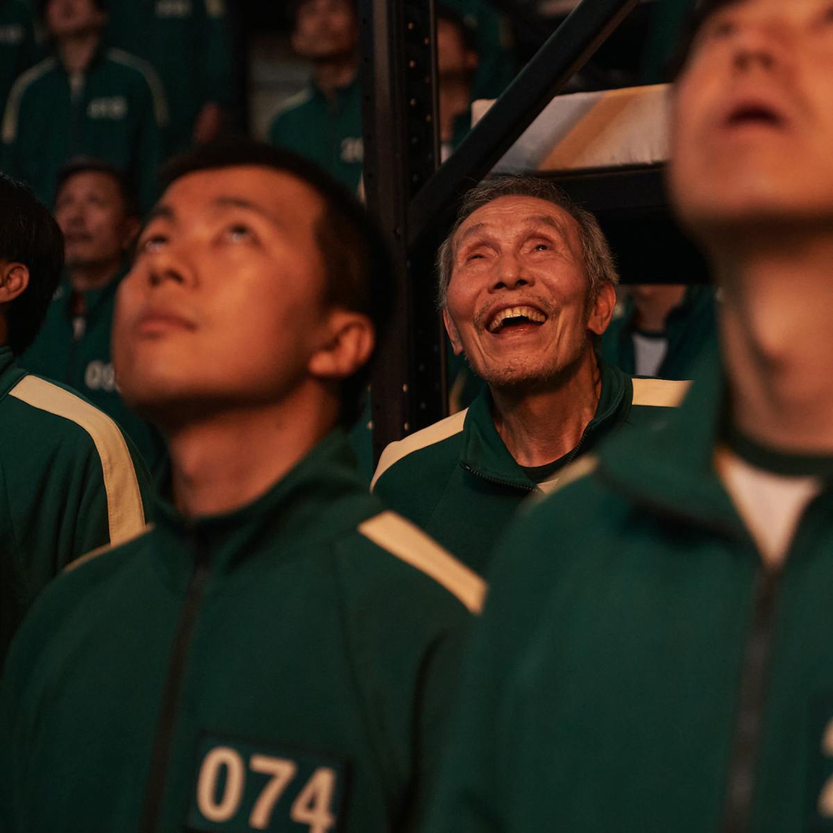 Oh Il-nam (Oh Young-soo) looks up in awe alongside other players in green tracksuits.