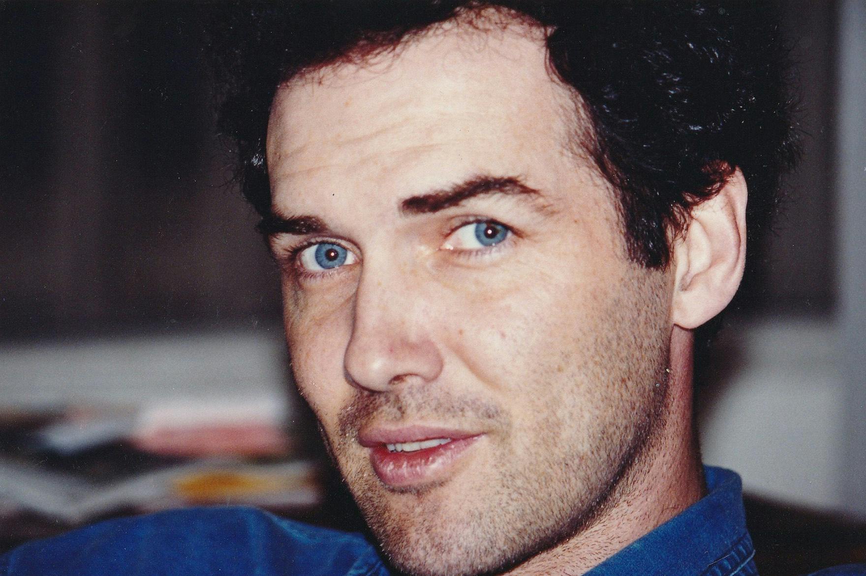 Norm Macdonald wears a blue shirt that matches his blue eyes. 