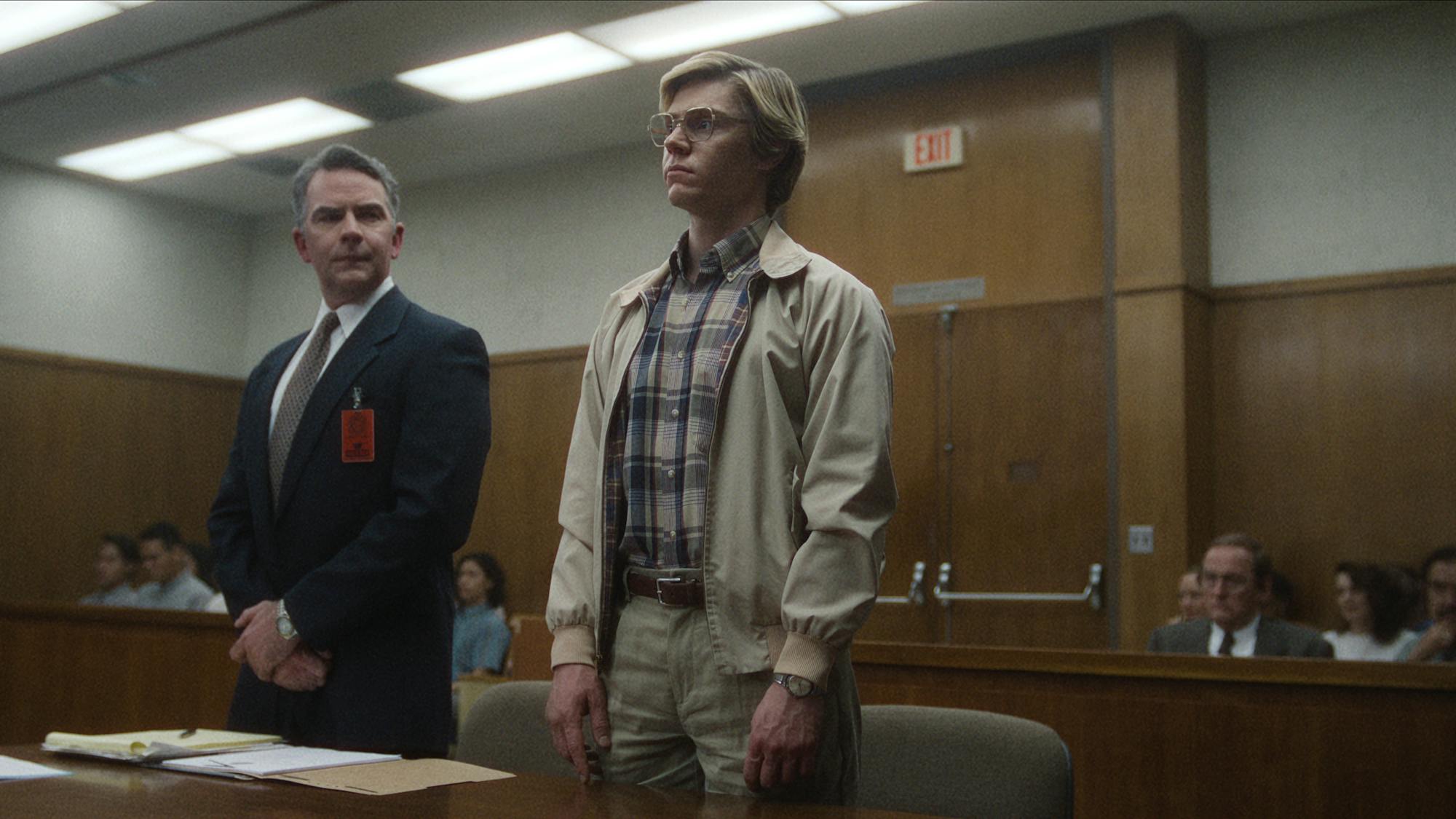 Jeffrey's lawyer (Rob Bush) and Jeffrey Dahmer (Evan Peters) stand together in court.
