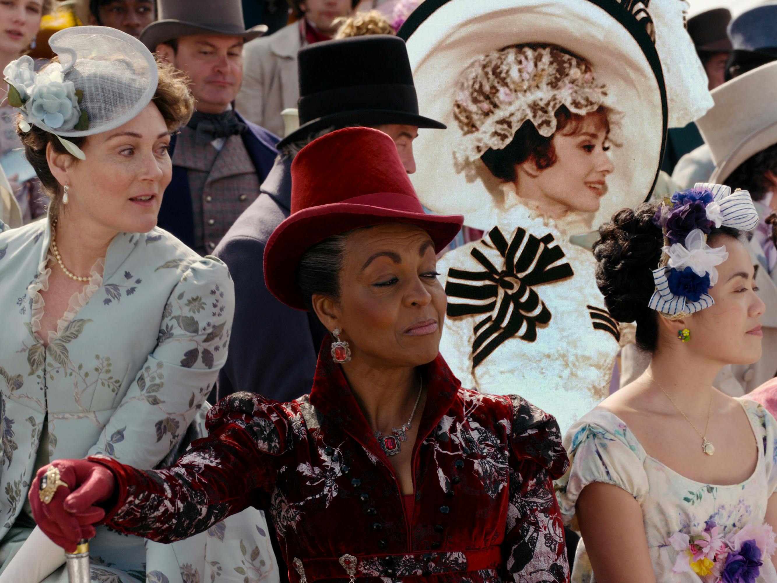 Lady Bridgerton (Ruth Gemmell) and Lady Danbury with Audrey Hepburn in My Fair Lady sit in the stands of the races.