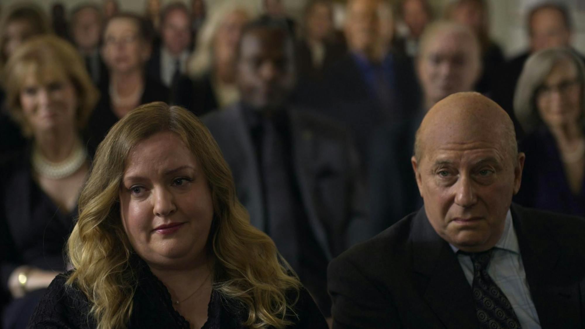 Sandy’s daughter, Mindy (Sarah Baker) and soon-to-be son-in-law, Martin (Paul Reiser) react to one of his eulogy’s more awkward moments.