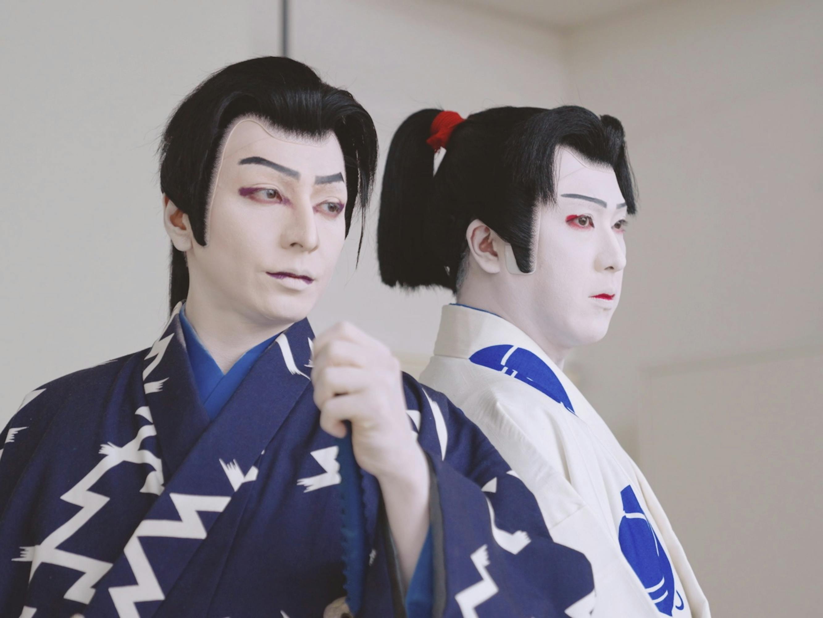 Two kabuki actors wear white and blue robes.