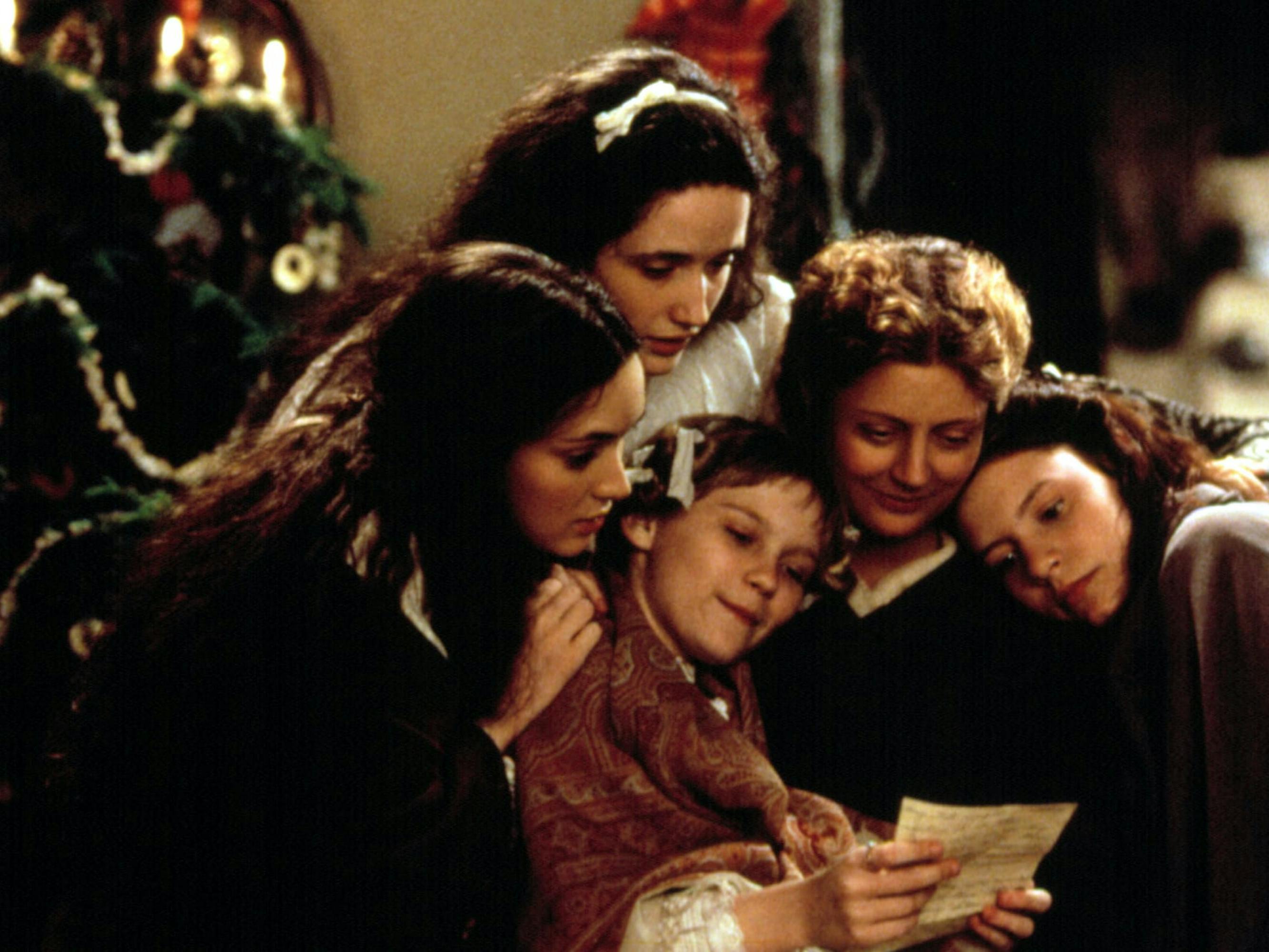 Jo March (Winona Ryder), Meg March (Trini Alvarado), Amy March (Kirsten Dunst), Mrs. March (Susan Sarandon), and Beth March (Claire Danes) sit huddle together reading a letter.