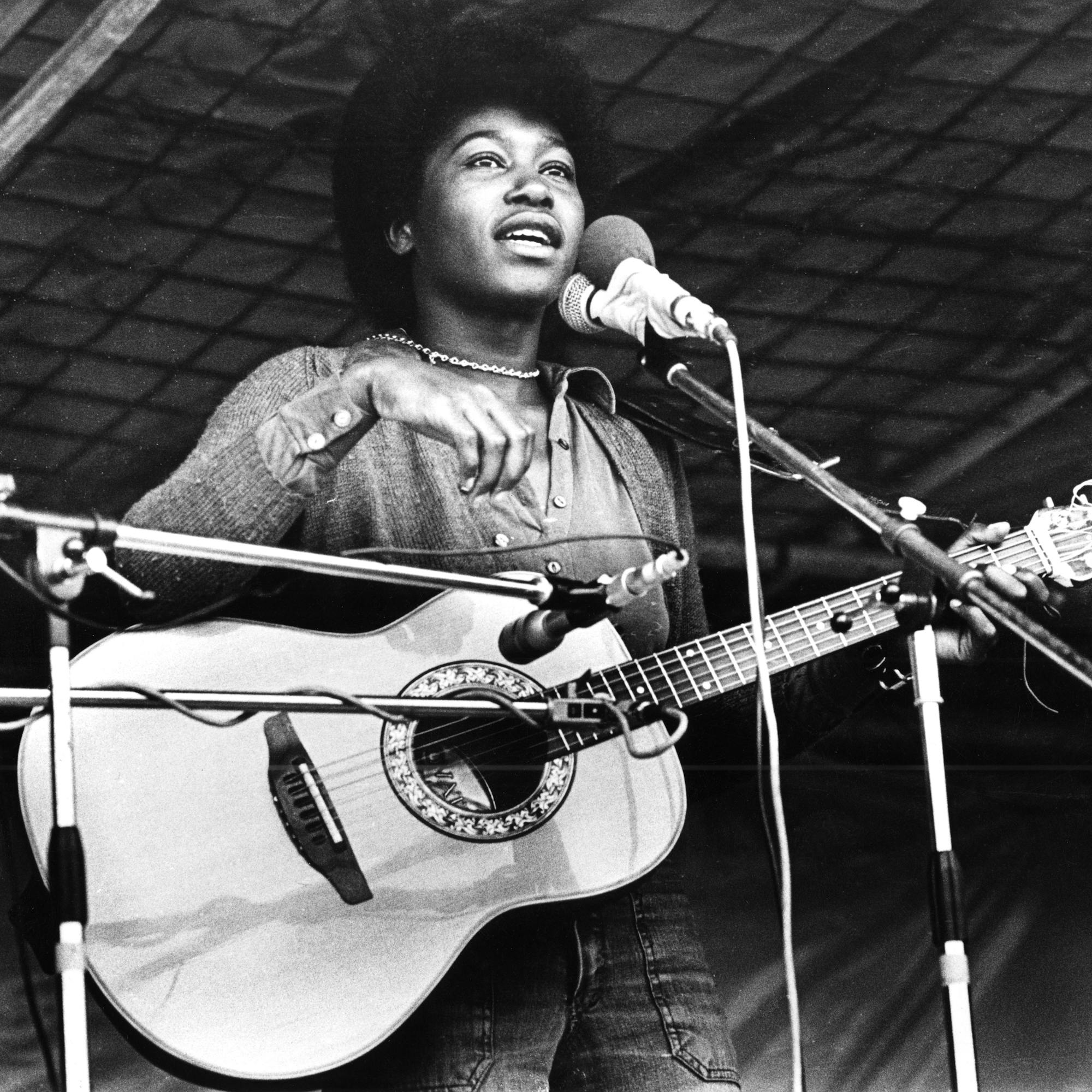 Joan Armatrading plays guitar in this black-and-white photo.