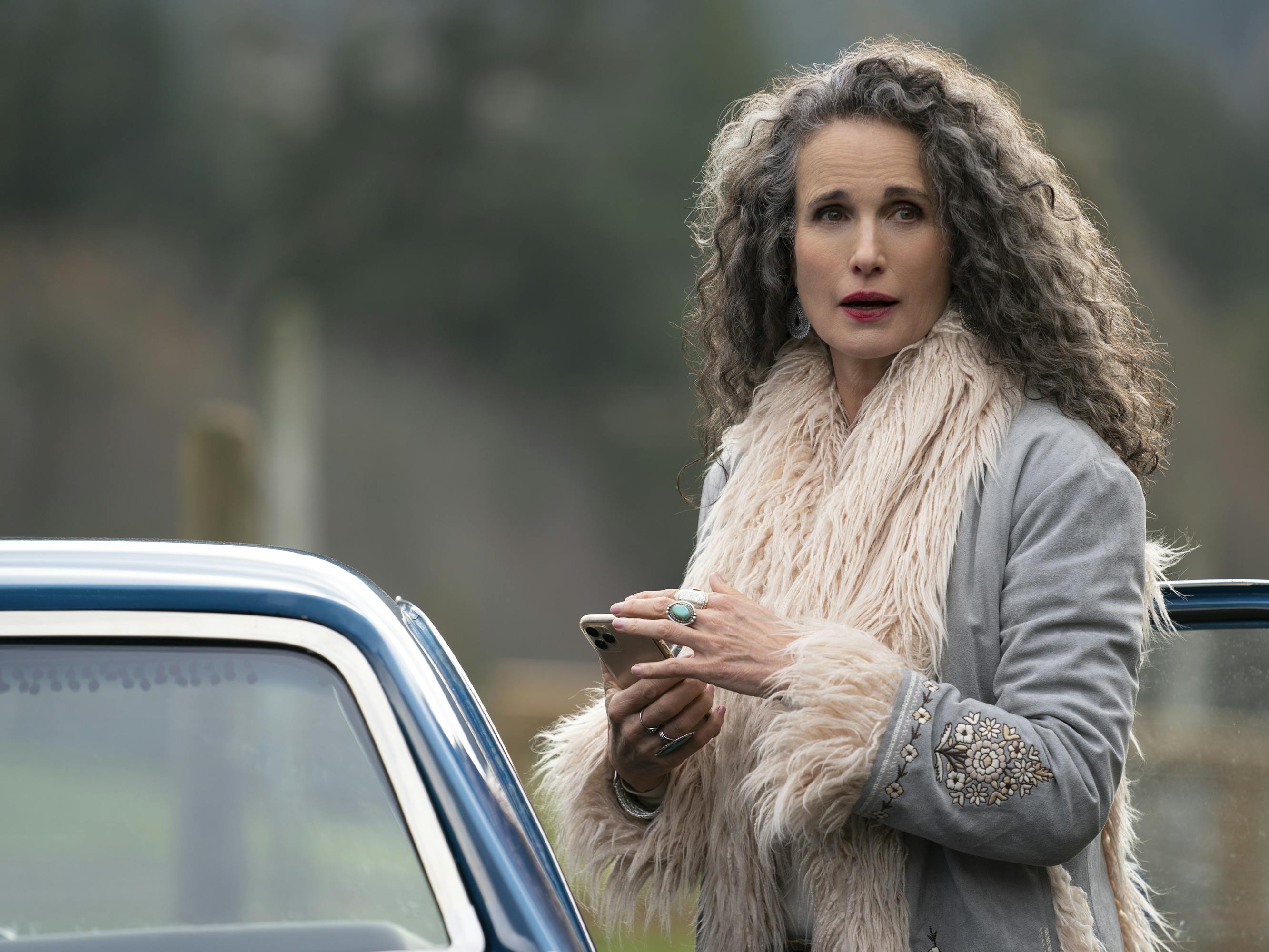 Paula (Andie MacDowell) wears a fur-lined jacket as she steps into a car.