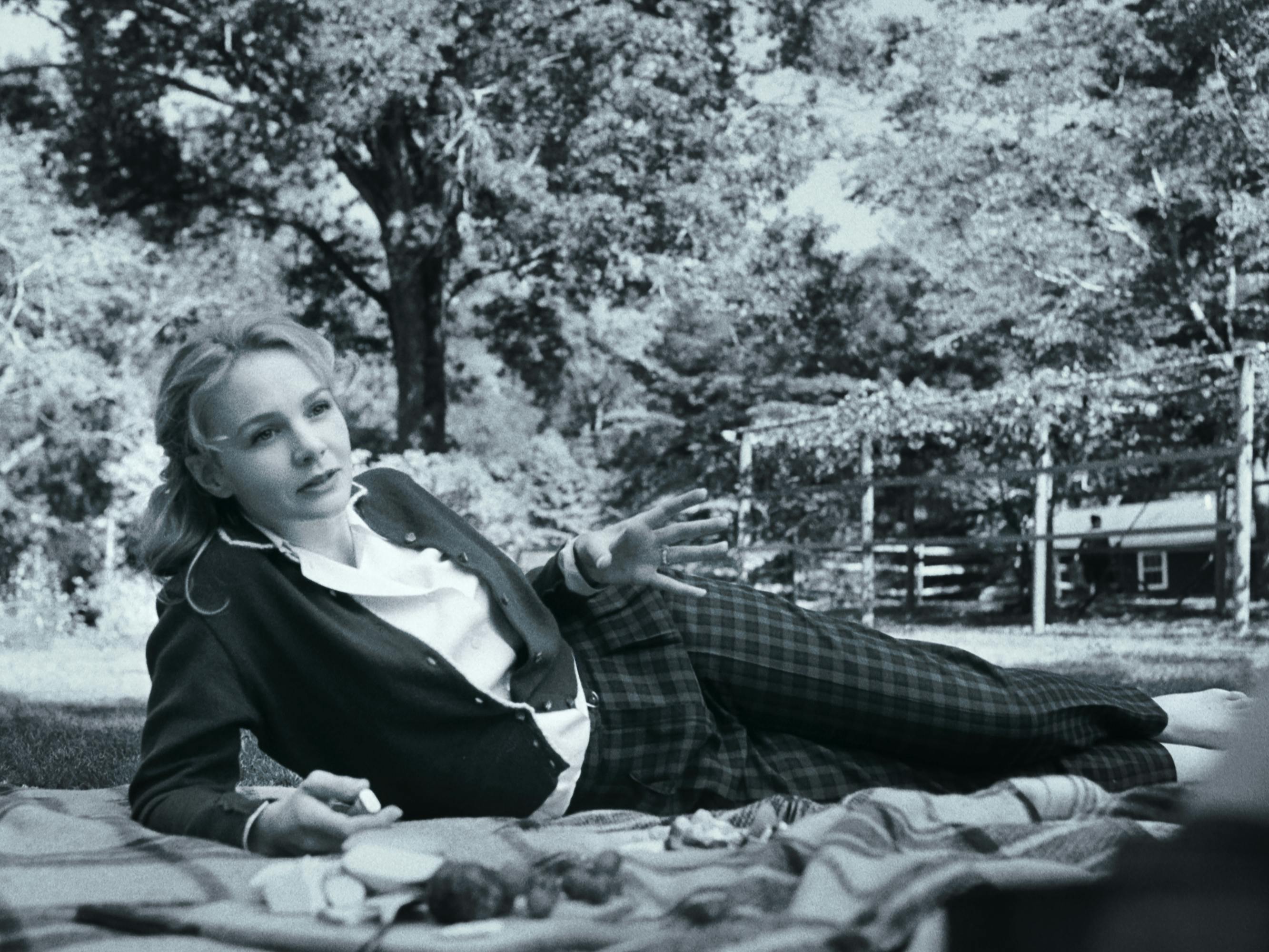 Felicia Montealegre Cohn Bernstein (Carey Mulligan) wears a fabulous outfit: plaid pants, a white blouse, and a cardigan.