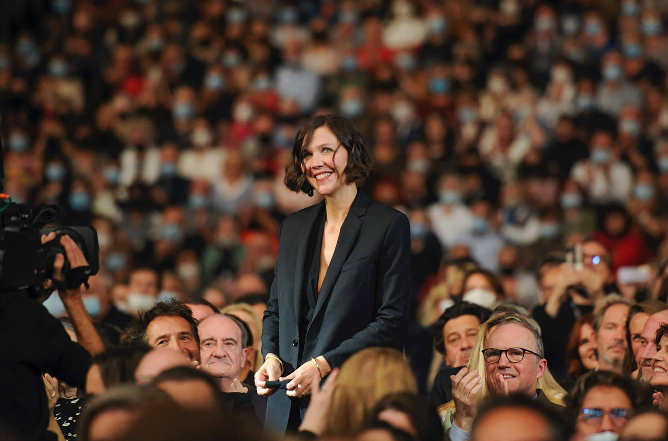 Maggie Gyllenhaal stands for applause in the auditorium