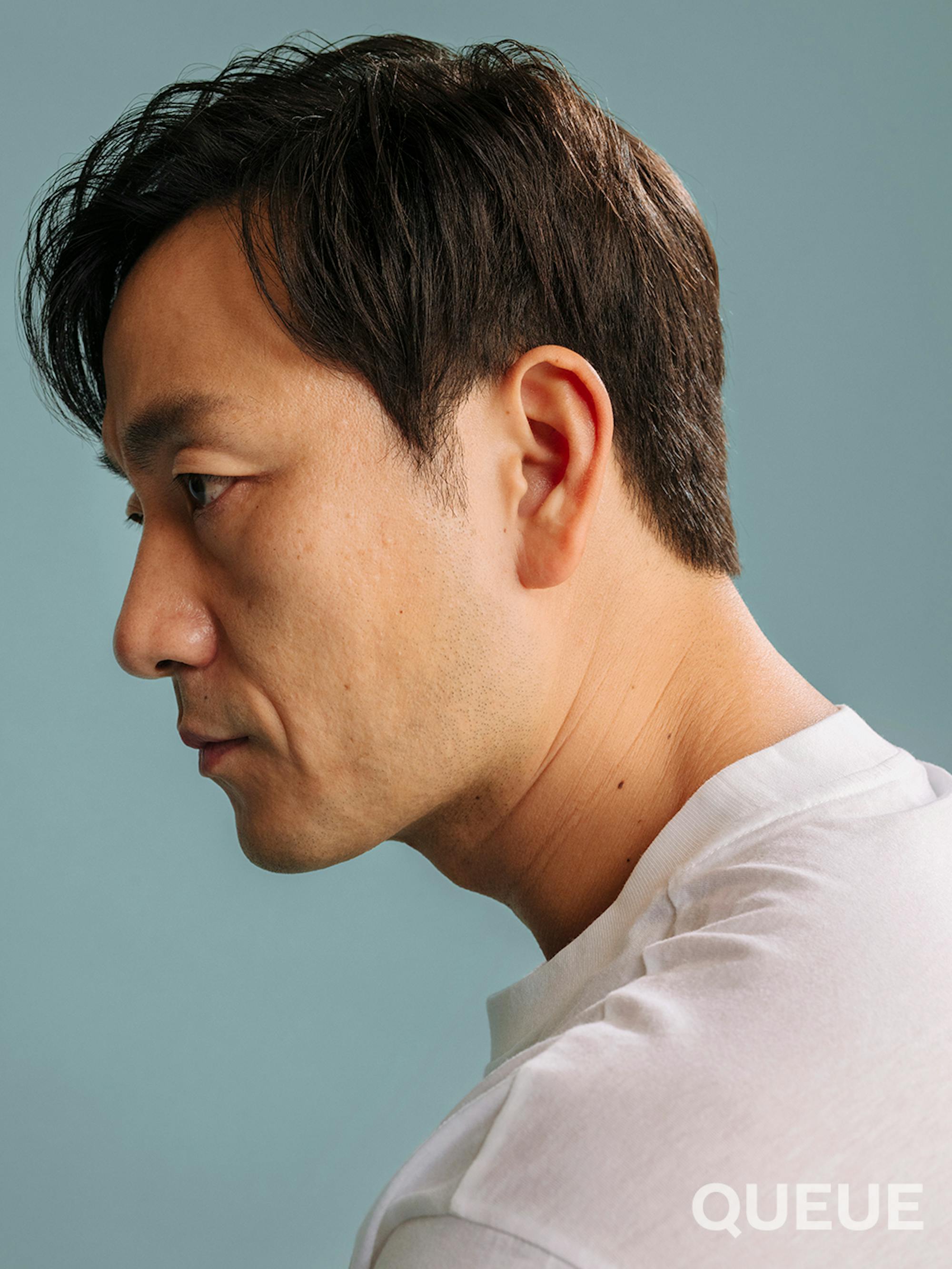 Park Hae-soo is seen in a close up shot of his profile looking serious with a white T-shirt on.